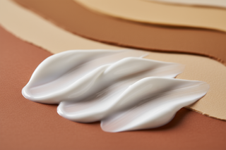 texture skincare dalla crema bianca e con lo sfondo dai toni della terra